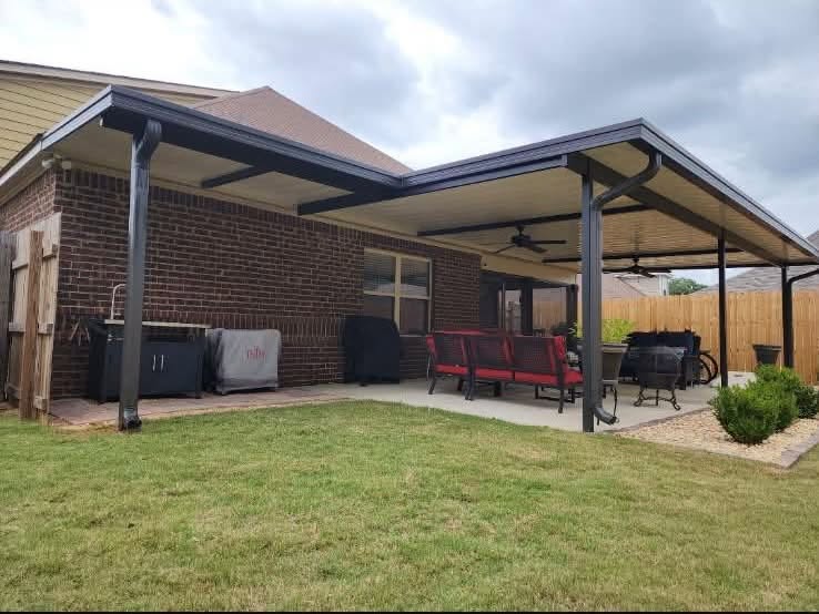 Dark gutters and downspouts around a covered backyard patio