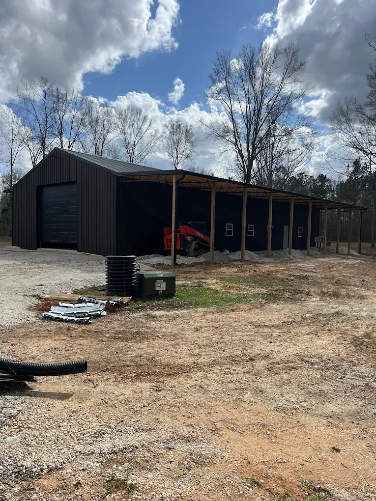 Dark barn front exterior with a covered side extension