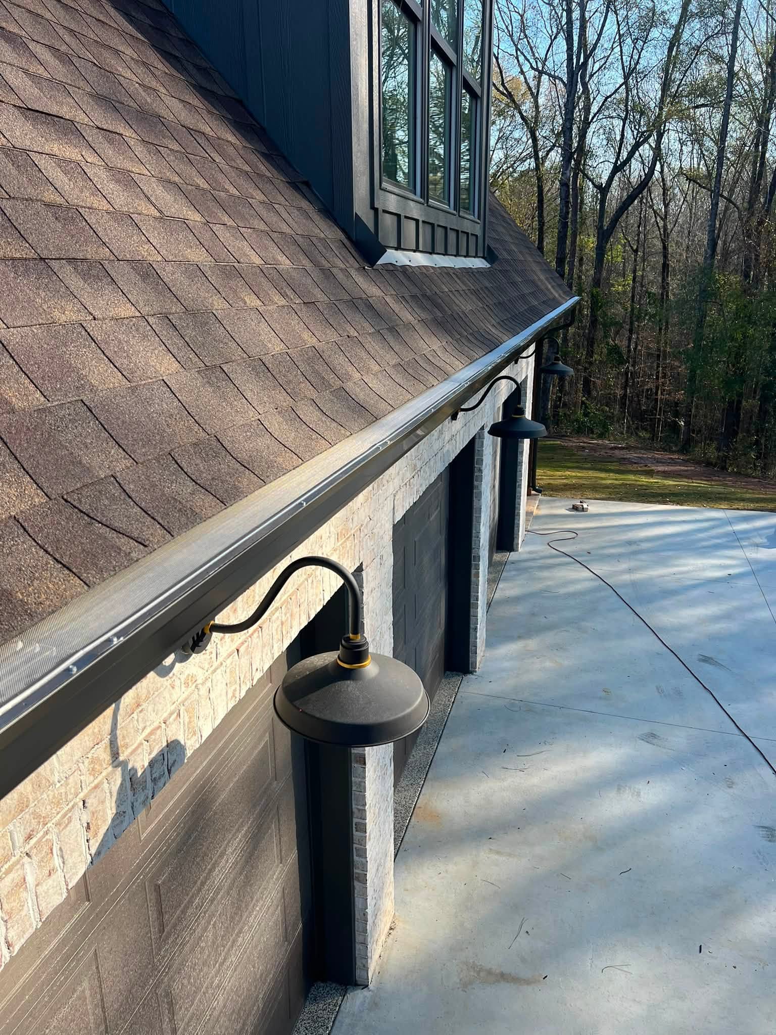 Gutter guard along a garage roof beside a dormer