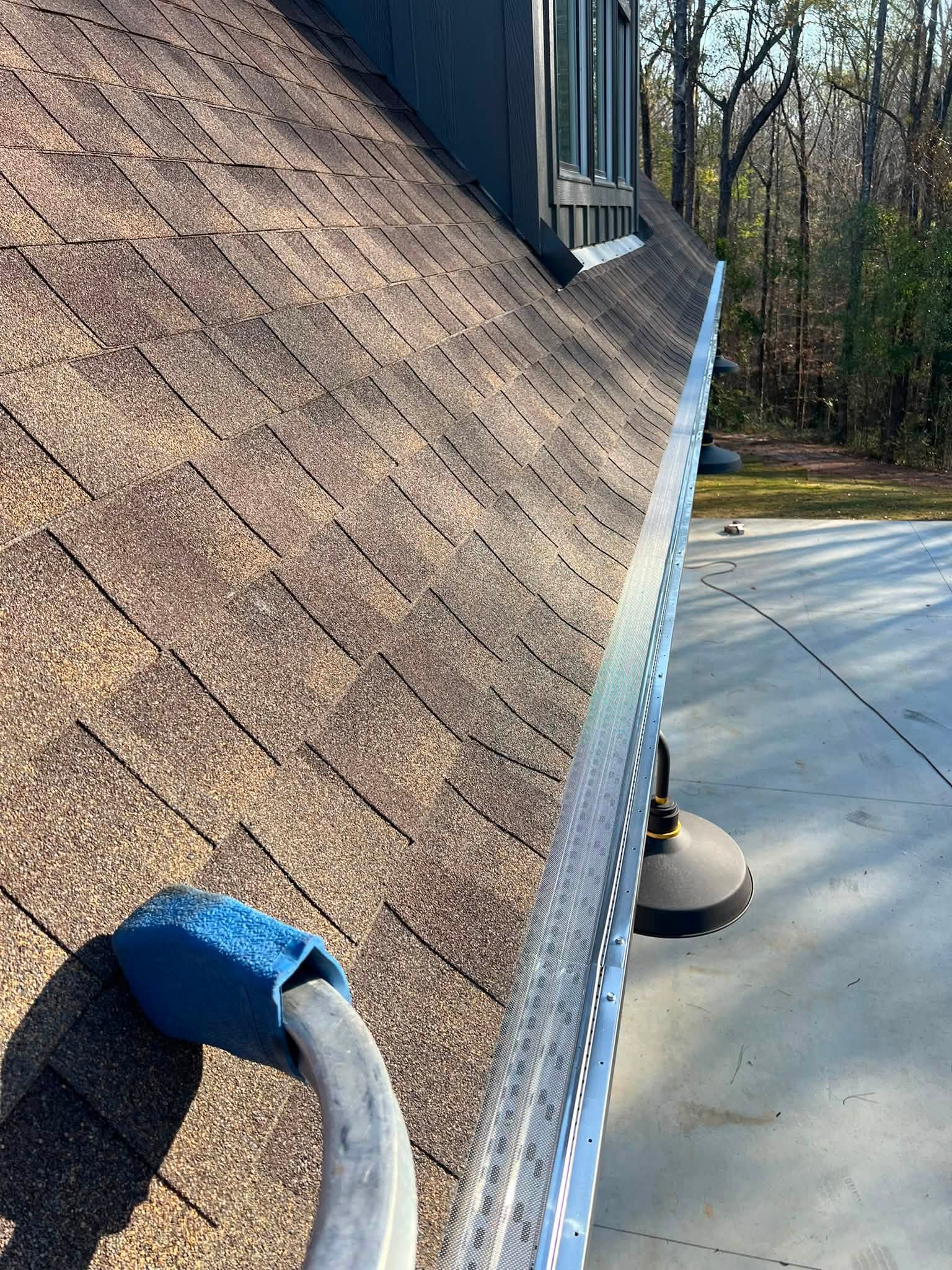 Mesh gutter protection along a garage roof edge