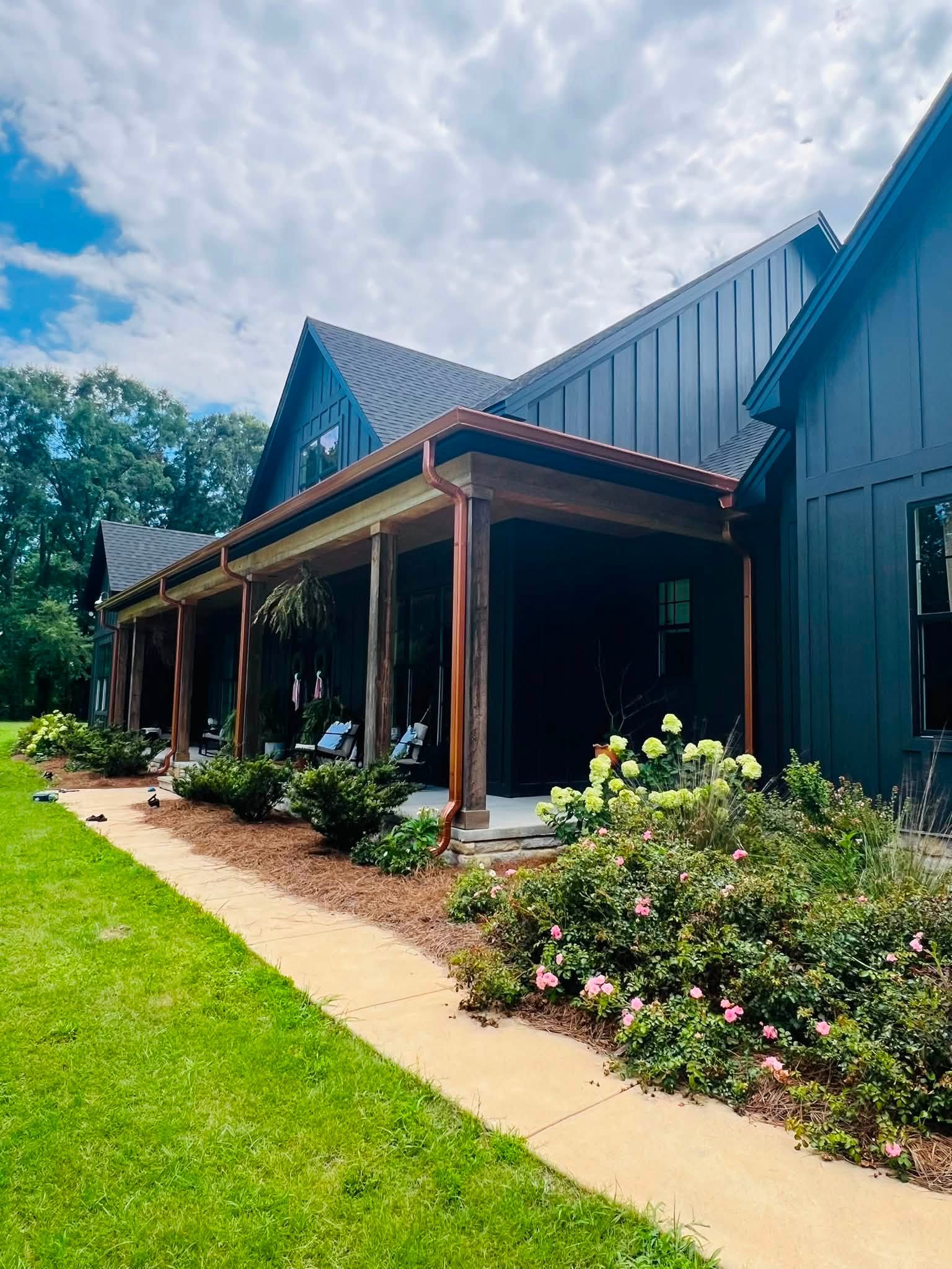 Copper-tone gutters and downspouts around a covered porch